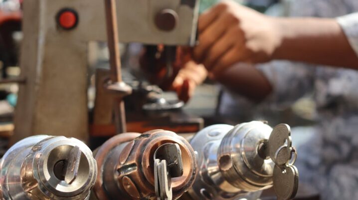 Close-up image of locksmith tools and hands working with a key machine outdoors. - Photo by Saad Bin Hasan on Pexels
