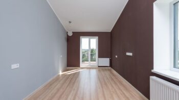 Spacious empty room featuring wooden flooring and a large window with natural light. - Photo by Max Vakhtbovych on Pexels