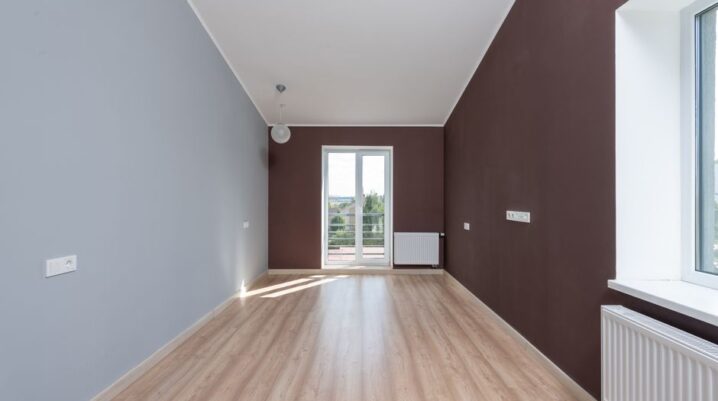 Spacious empty room featuring wooden flooring and a large window with natural light. - Photo by Max Vakhtbovych on Pexels