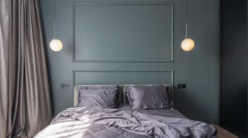 Interior design of modern bedroom with unmade bed under luminous lamps at sunlight - Photo by Max Vakhtbovych on Pexels
