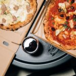 Top view of delicious pizzas in boxes with a refreshing drink, perfect for a cozy meal. - Photo by KoolShooters on Pexels