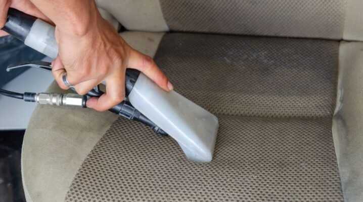 Hands using a vacuum nozzle to deeply clean a fabric car seat, removing dirt and stains. - Photo by Khunkorn Laowisit on Pexels