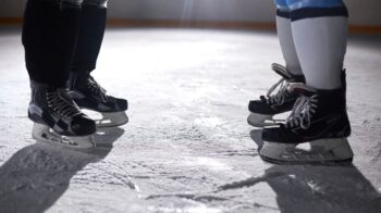 A close-up view of two pairs of ice skates on an ice rink, highlighting the skating gear. - Photo by Tony Schnagl on Pexels