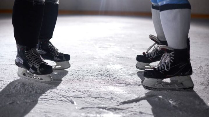 A close-up view of two pairs of ice skates on an ice rink, highlighting the skating gear. - Photo by Tony Schnagl on Pexels