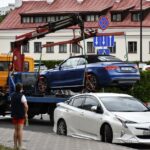 Towing a blue Audi convertible in a bustling city street. - Photo by Artem Makarov on Pexels