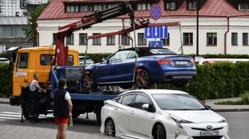 Towing a blue Audi convertible in a bustling city street. - Photo by Artem Makarov on Pexels