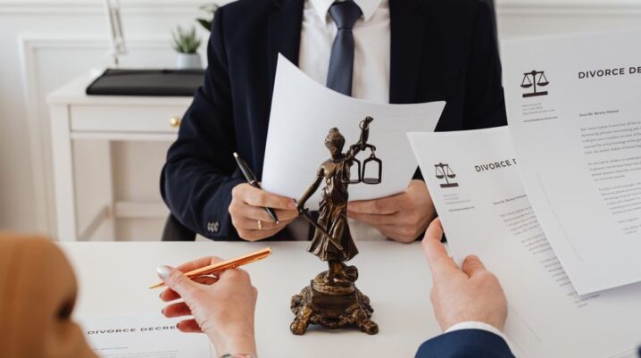 Legal professionals reviewing divorce documents in a law office with a Lady Justice statue. - Photo by https://kaboompics.com/ on Pexels